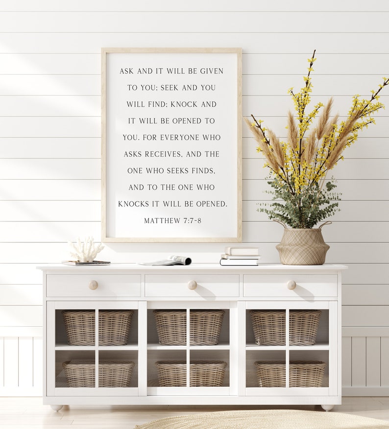 K&ouml;nnte beinhalten: Ein rechteckiges Wandschild in einem hellen Holzrahmen mit schwarzem Text: ASK AND IT WILL BE GIVEN TO YOU: SEEK AND YOU WILL FIND; KNOCK AND IT WILL BE OPENED TO YOU. FOR EVERYONE WHO ASKS RECEIVES. AND THE ONE WHO SEEKS FINDS. MATTHEW 7:7-8
