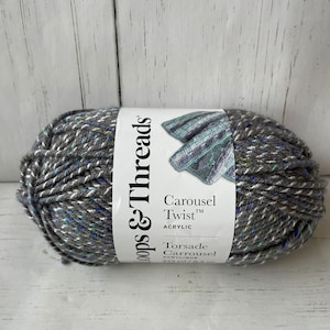 May include: A skein of Loops & Threads Carousel Twist acrylic yarn in a gray and blue colorway. The label reads "Carousel Twist™ Acrylic, Torsade Carrousel."