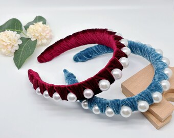 May include: Two velvet headbands with pearl embellishments. One headband is burgundy and the other is teal.