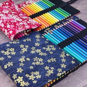 May include: Colored pencils in a roll-up case with a floral pattern. The case is made of fabric and has multiple compartments to hold the pencils. The pencils are arranged by color, creating a rainbow effect. The case is a vibrant and organized way to store art supplies.