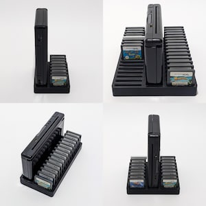 May include: Black plastic game cartridge holder with a Nintendo DS console. The holder has slots for game cartridges and a vertical slot for the console. Several game cartridges are visible, with colorful game labels.