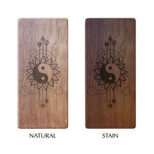 K&ouml;nnte beinhalten: Zwei Holz-Handygriffe mit einem Yin-Yang-Symbol und geometrischen Mustern. Der Griff links ist aus Naturholz, w&auml;hrend der Griff rechts gebeizt ist.