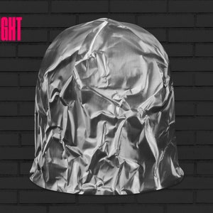 May include: A crumpled silver foil ball, resembling a helmet, against a black brick wall background. The word "RIGHT" is written in pink letters above the ball.