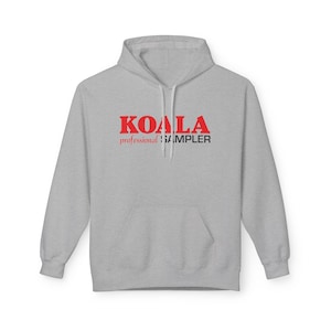 Puede incluir: Sudadera con capucha gris con el texto "KOALA professional SAMPLER" en letras rojas y negras.