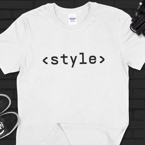 May include: White t-shirt with the text "<style>" printed in black.