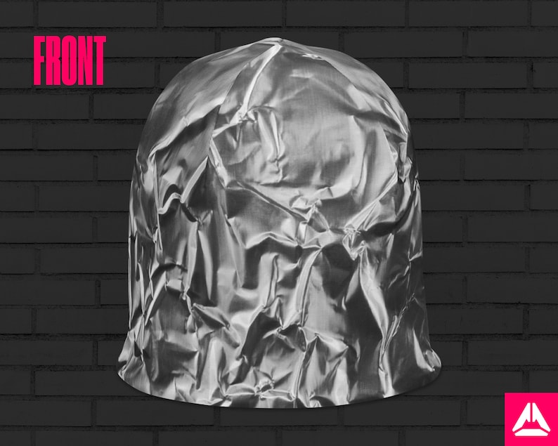 May include: A crumpled silver foil dome shaped object against a black brick wall background.