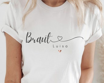 May include: White t-shirt with the text "Braut Luisa" and a small pink heart.