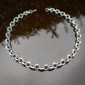 Puede incluir: Un collar de cadena de plata con un dise&ntilde;o de eslabones gruesos y redondeados.