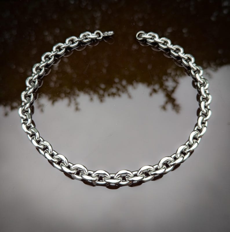 Puede incluir: Un collar de cadena de plata con un dise&ntilde;o de eslabones gruesos y redondeados.