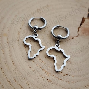 May include: A pair of silver hoop earrings with a dangling outline of the continent of Africa.