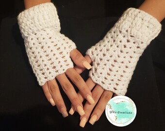 May include: White crocheted fingerless gloves with a lacy pattern. The gloves are shown on a person's hands with light peach-colored nail polish.