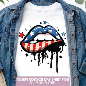 Può includere: Una t-shirt bianca con una grafica di labbra, con il labbro superiore blu a stelle bianche e quello inferiore a strisce rosse e bianche. Gocce nere simili a vernice colano verso il basso, circondate da piccole stelle rosse e blu.