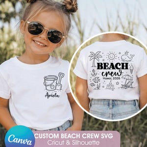 May include: A young girl wearing a white t-shirt with a beach-themed design. The front of the shirt features a bucket, shovel, and the name "Ariela". The back of the shirt has a "Beach Crew" graphic with a palm tree, whale, and other beach elements.