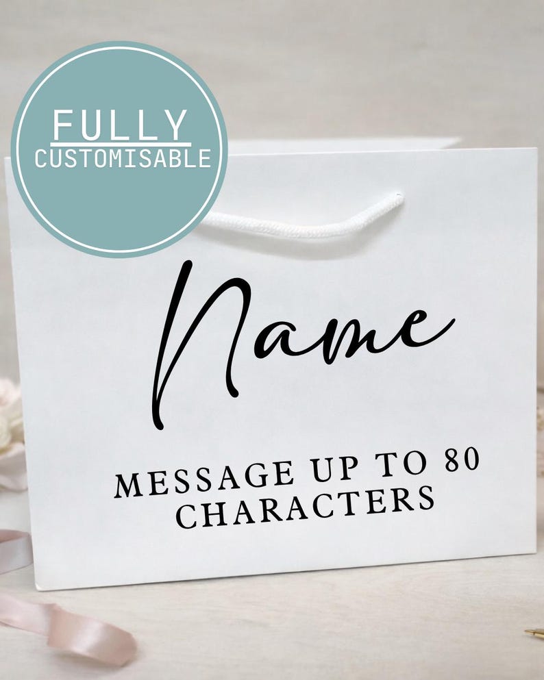 May include: White gift bag with a white rope handle. The bag features the word "Name" in a black script font, and the text "MESSAGE UP TO 80 CHARACTERS" in a black sans-serif font. A teal circle with the words "FULLY CUSTOMISABLE" is in the upper left corner.