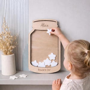 May include: A wooden reward jar in the shape of a mason jar, with the name "Alice" engraved at the top. It features a space for white star-shaped tokens and the words "Reward Jar" engraved at the bottom.