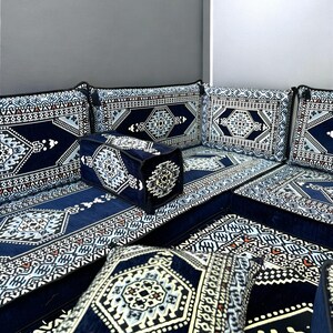 May include: A blue and white patterned floor seating set with cushions. The set includes a large couch, two armrests, and several smaller cushions. The fabric is a soft, plush velvet.