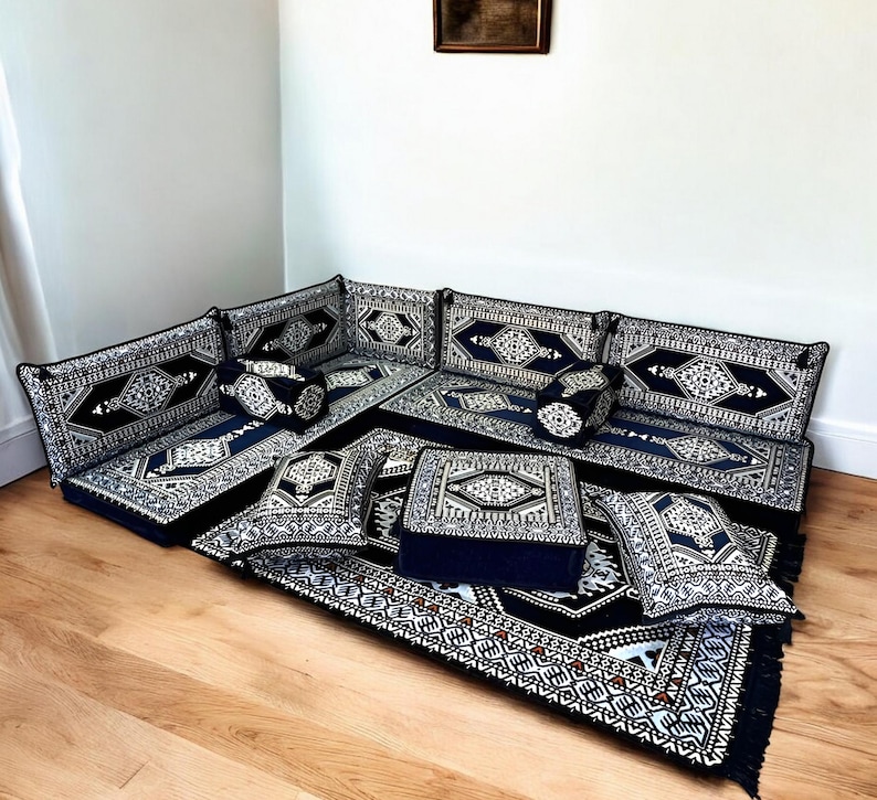 May include: A black and white patterned floor cushion set with a matching rug. The cushions are arranged in a U-shape to form a seating area. The cushions are made of a soft, plush fabric and have a comfortable, firm filling.