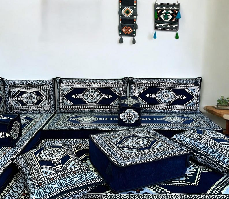 May include: A blue and white patterned floor cushion set with a variety of sizes and shapes. The cushions are arranged in a living room setting with a blue and white patterned rug.