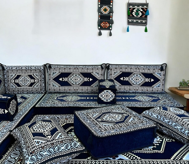 May include: A blue and white patterned floor cushion set with a variety of sizes and shapes. The cushions are arranged in a living room setting with a blue and white patterned rug.