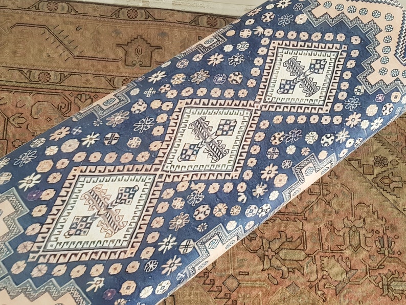 May include: A blue and cream patterned rug with a diamond design. The rug has a traditional Persian style.