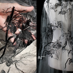 Könnte beinhalten: Schwarzer floraler Spitzenstoff mit einem zarten, filigranen Design. Die Spitze ist durchsichtig und hat eine weiche, fließende Textur.