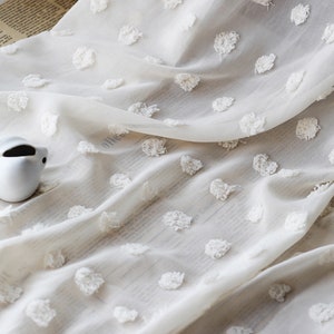 Puede incluir: Tela blanca transparente con un patrón de lunares blancos texturizados. La tela es suave y delicada, perfecta para cortinas u otros proyectos de decoración del hogar.