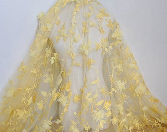 May include: Yellow floral lace fabric with 3D flowers. The fabric has a delicate, sheer texture and is perfect for adding a touch of elegance to any project.