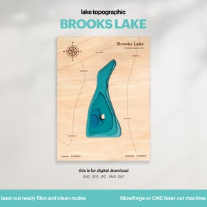 May include: A laser cut wooden map of Brooks Lake in Pennsylvania, USA. The lake is depicted in shades of blue, with contour lines showing the depth of the lake. The map is surrounded by a wooden frame and includes a compass rose.