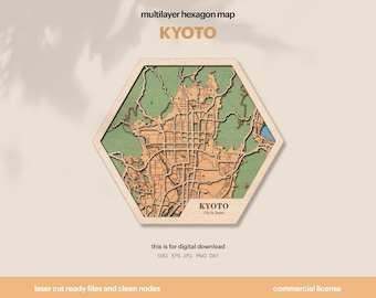 Può includere: Una mappa esagonale multistrato in legno di Kyoto, Giappone. La mappa presenta un design dettagliato tagliato al laser con una cornice in legno chiaro, interni verdi e beige e il nome della città. Il testo "KYOTO" è visualizzato in modo prominente.
