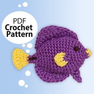 May include: A purple crocheted fish with yellow fins and a brown eye. The fish is a crochet pattern, available as a PDF download.