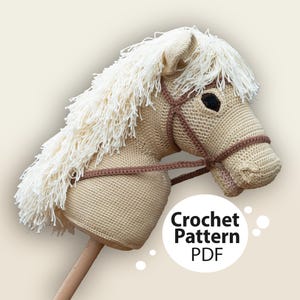 May include: Crochet pattern PDF for a beige and white crocheted rocking horse head. The horse has a brown leather bridle and a white mane.