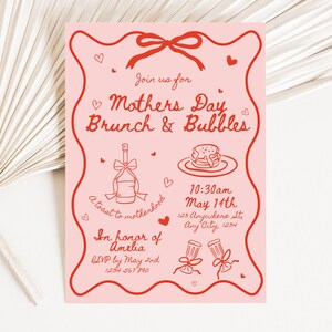 May include: Pink invitation with red text for a Mother's Day brunch and bubbles event. The invitation includes a date and time, location, and RSVP information. It also features a toast to motherhood illustration and a brunch illustration.