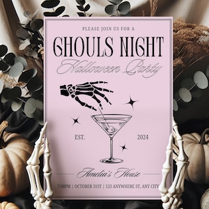 May include: A pink invitation card with black text that reads "Please join us for a Ghouls Night Halloween Party". The card features a black skeleton hand holding a martini glass with an olive. The text "EST. 2024" is below the martini glass. The text "Amelia's House" is below the martini glass. The text "7:00PM | OCTOBER 31ST | 123 ANYWHERE ST, ANY CITY" is at the bottom of the card.