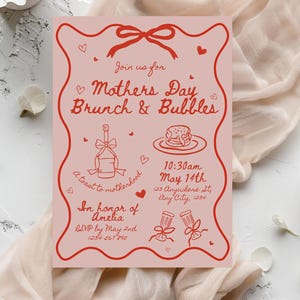 May include: Pink invitation with red text and illustrations for a Mother's Day brunch and bubbles event. The invitation includes the date, time, and location of the event, as well as a request to RSVP by May 2nd. The text reads "Join us for Mother's Day Brunch & Bubbles, 10:30am May 14th, 123 Anywhere St, Any City, 1234, A toast to motherhood, In honor of Amelia, RSVP by May 2nd, 1234 567 8910."