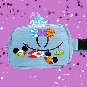 May include: A light blue fanny pack with a black buckle, adorned with cartoon character designs. The pack features a Mickey Mouse ear headband with a purple bow and various character-themed charms, including a Pizza Planet sign.