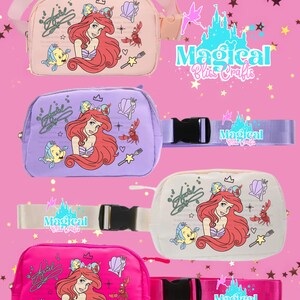 May include: Four colourful fanny packs featuring Ariel from The Little Mermaid, with Flounder and Sebastian. Each bag is a different colour: pink, lavender, white, and hot pink. The bags have adjustable straps and the text "Magical Bliss Crafts".