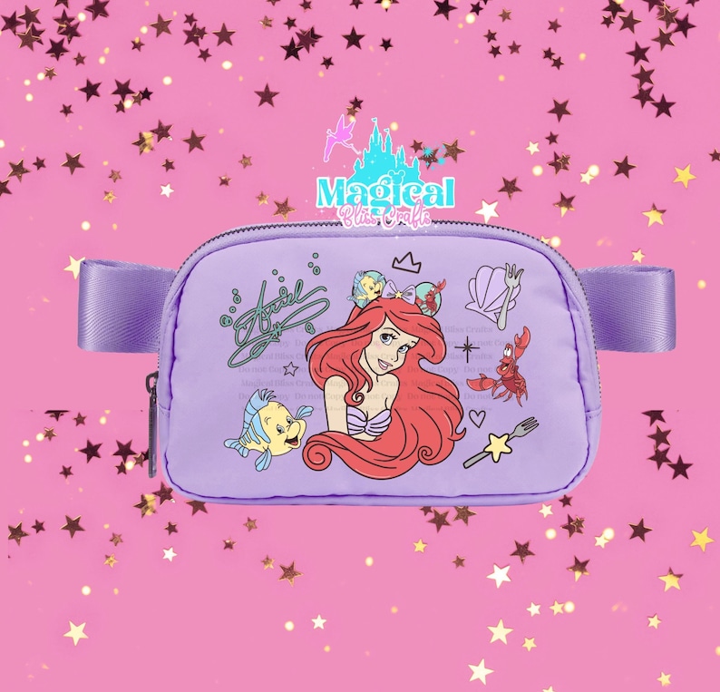 May include: A lavender fanny pack featuring Ariel from The Little Mermaid. The design includes Ariel, Flounder, Sebastian, and other themed graphics. The bag has a zip closure and a lavender strap.