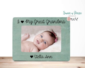 May include: A teal wooden picture frame with the text "I love my Great Grandma" and "Stella Ann" in black lettering. A photo of a baby girl is in the frame.