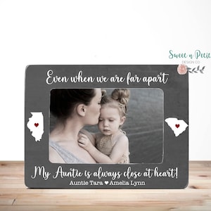 May include: Gray wooden picture frame with a white silhouette of Illinois and South Carolina with red hearts in the center of each state. The frame has the text "Even when we are far apart, My Auntie is always close at heart! Auntie Tara Amelia Lynn".