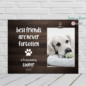 May include: A brown wooden frame with a white paw print and the text "best friends are never forgotten" in loving memory Cooper 2020. A photo of a white dog with a sad expression is in the frame.