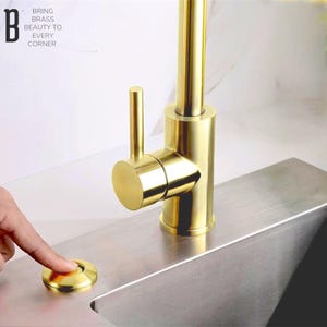 Puede incluir: Una taza de cerámica blanca con un asa negra y el texto "But First, Coffee" en negrita negra. La taza se encuentra sobre un fondo borroso, sugiriendo un ambiente acogedor.