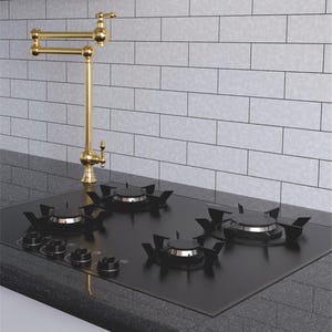 May include: A black four-burner gas cooktop with matte black grates and four control knobs, paired with a tall, articulated gold-toned pot filler faucet featuring a swivel spout and a single handle, mounted on a dark gray granite countertop.