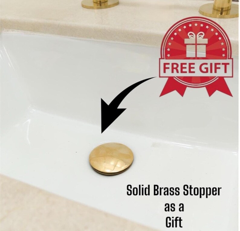 May include: A solid brass stopper with a light brown, patterned surface. The stopper is shown in a white sink. The image includes a red and white "FREE GIFT" badge and the text "Solid Brass Stopper as a Gift."