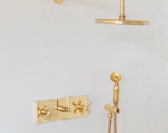 Sistema de chuveiro de parede artesanal em latão sem verniz, com ducha tipo chuva.