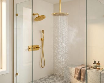 May include: A modern shower setup with gold fixtures. The image shows a large, round rain shower head, a handheld shower, and a wall-mounted control panel. The shower is enclosed in glass, with a marble bench and a towel.