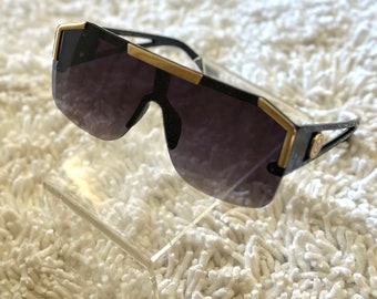 Gafas de sol sin montura: detalles en negro y dorado, lentes degradados