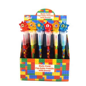 May include: A display box of multi-point pop colour pencils with stamps. The pencils are in a variety of colours and have a star-shaped top with a different coloured stamp on each. The box is decorated with a colourful Lego-like pattern and the text "Multi-Point Pop Colour Pencils with Stamp" is printed on the front.