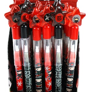 May include: A display box of red and black pop pencils with a ninja character design. The pencils have a star-shaped top with a ninja character and the word "忍" (nin) on it. The box has a warning label that says "CHOKING HAZARD - Small parts. Not for children under 3 years."