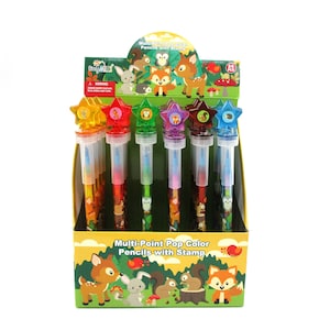 Könnte beinhalten: Eine Anzeige von 24 Multi-Point Pop-Farbstiften mit Stempeln. Die Stifte haben farbenfrohe sternförmige Oberteile mit Tiermotiven. Die Displaybox zeigt ein Waldthema mit Tieren wie Hirschen, Eichhörnchen und Füchsen.