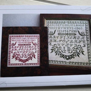 Könnte beinhalten: Ein gedrucktes Kreuzstichmuster mit zwei gerahmten Samplern. Die Sampler zeigen Alphabete, Zahlen und florale Designs in roter und grüner Farbe. Der Text "The Lost French Red - Les Escargots Perdu" ist auf der linken Seite des Bildes aufgedruckt.